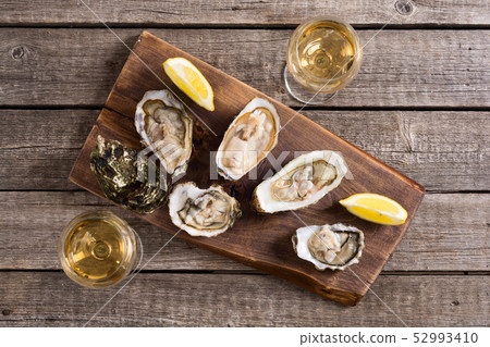 Fresh Oysters with lemon and white wine 52993410