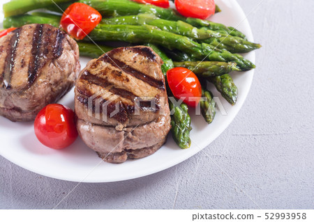 Grilled filet mignon with asparagus and tomatoes 52993958