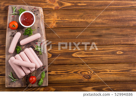 Raw beef sausages with pepper , herbs and ketchup 52994886