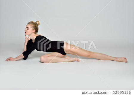 gymnast barfoot woman is sitting on the floor in studio gymnast barfoot woman is sitting on the floor in studio 52995136