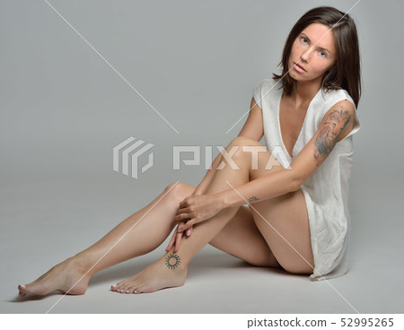 beautiful barefoot woman in white blouse is sitting on the floor 52995265