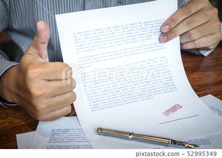 Hands of businessman stamp on paper document to 52995349