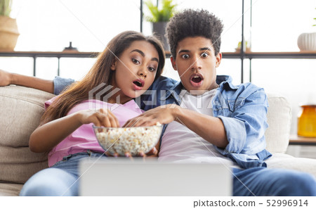 Shocked teen couple watching scary movie on laptop 52996914