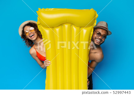 Happy african couple looking out yellow air mattress Happy african couple looking out yellow air mattress 52997443