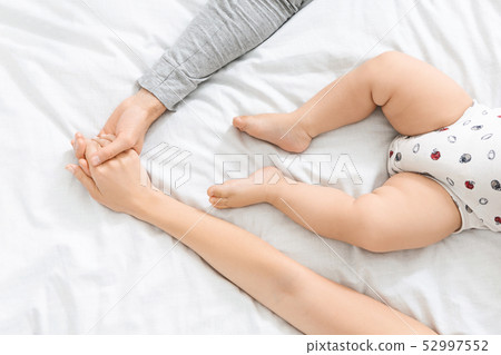 Young parents holding hands and cute little baby near them Young parents holding hands and cute little baby near them 52997552