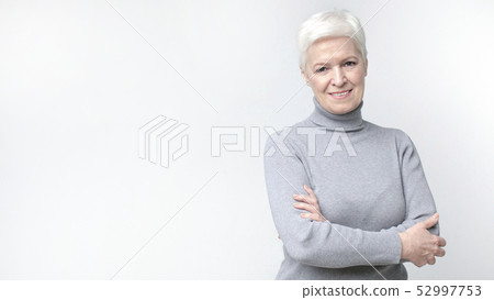 Confident smiling beautiful aged woman on light background Confident smiling beautiful aged woman on light background 52997753