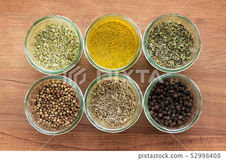 Six glass jars with spices on wooden background 52998408