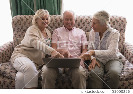 Senior people using laptop in living room 53000236