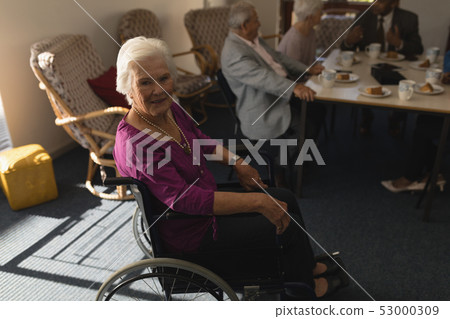 Side view of disable senior woman sitting on wheel chair and looking at camera Side view of disable senior woman sitting on wheel chair and looking at camera 53000309