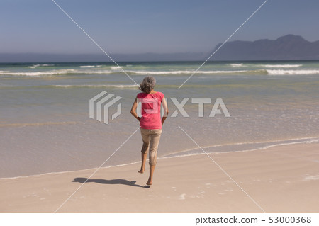 Senior woman running on beach Senior woman running on beach 53000368
