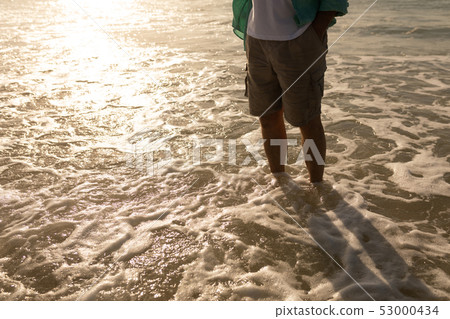 Senior man standing on the sea at beach Senior man standing on the sea at beach 53000434