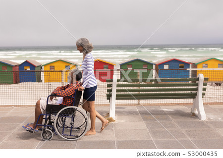 Senior man and senior woman walking on promenade 53000435