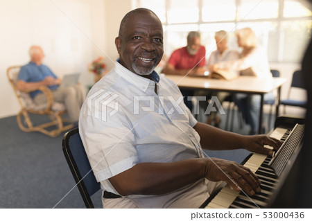 Senior man playing piano at nursing home Senior man playing piano at nursing home 53000436