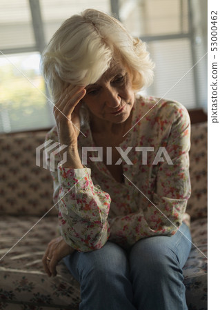 Worried senior woman relaxing on sofa in living room 53000462