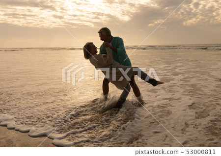 Senior couple dancing together on the beach 53000811