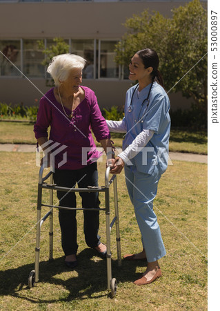 Young female doctor helping disabled senior woman in garden Young female doctor helping disabled senior woman in garden 53000897