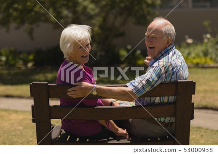 Senior couple sitting together on the bench in the park Senior couple sitting together on the bench in the park 53000938