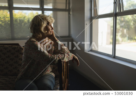 Senior woman relaxing in living room at nursing home Senior woman relaxing in living room at nursing home 53001030