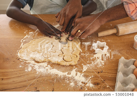 African American father and son baking cookies in kitchen African American father and son baking cookies in kitchen 53001048