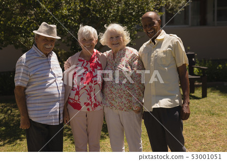 Front view of senior friends looking at camera in garden Front view of senior friends looking at camera in garden 53001051