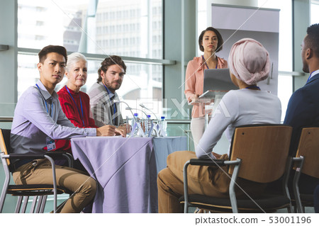 Business people looking at camera in a business seminar 53001196