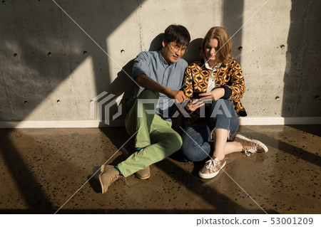 Male and female executives using mobile phone in office Male and female executives using mobile phone in office 53001209