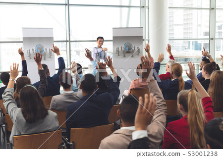 Business people raising hands in a business seminar Business people raising hands in a business seminar 53001238