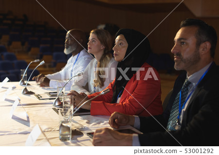Business executive looking and listening while sitting in the auditorium Business executive looking and listening while sitting in the auditorium 53001292