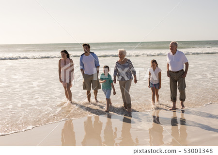 Happy multi-generation family walking and having fun on beach Happy multi-generation family walking and having fun on beach 53001348