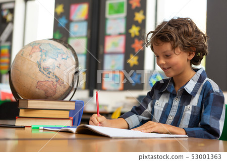 Schoolboy studying at desk in the classroom 53001363