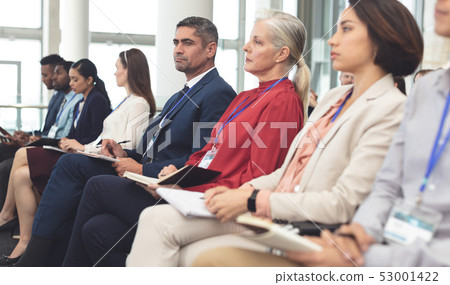 Side view of business people attending a business seminar 53001422