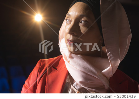 Businesswoman looking and thinking while standing on stage in auditorium 53001439