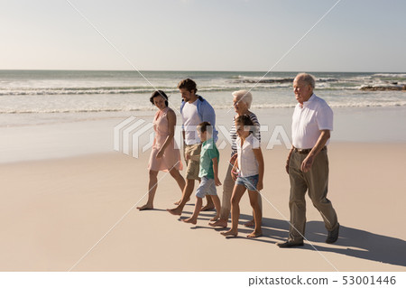 Happy multi-generation family walking and having fun on beach Happy multi-generation family walking and having fun on beach 53001446