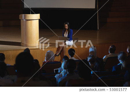 Businesswoman sitting at the side of the stage and having laptop in her hand  53001577