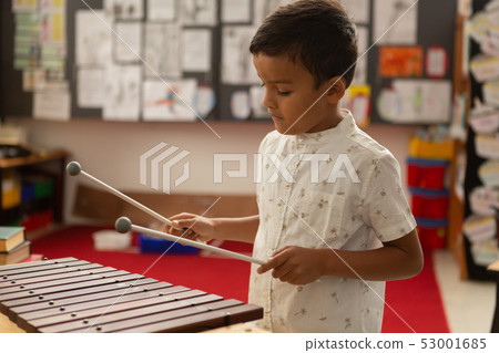 Schoolboy playing xylophone in a classroom Schoolboy playing xylophone in a classroom 53001685
