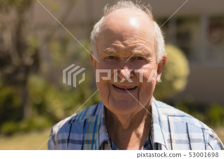 Close- up of senior man looking at camera in garden Close- up of senior man looking at camera in garden 53001698