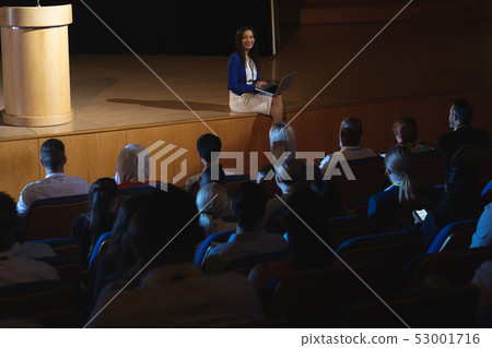 Businesswoman sitting at the side of the stage and having laptop in her hand Businesswoman sitting at the side of the stage and having laptop in her hand 53001716