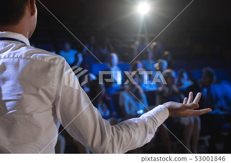 Businessman giving presentation in front of audience in auditorium 53001846