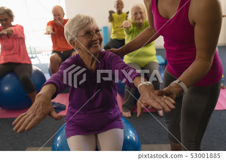 Female trainer assisting senior woman in fitness studio Female trainer assisting senior woman in fitness studio 53001885