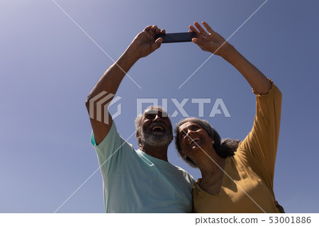 Senior couple taking selfie with mobile phone on beach Senior couple taking selfie with mobile phone on beach 53001886