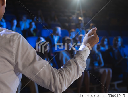 Businessman giving presentation in front of audience in auditorium 53001945