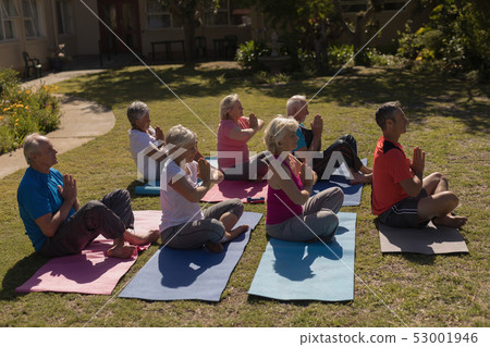 Trainer training senior people in performing yoga Trainer training senior people in performing yoga 53001946