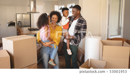 Happy African American parents with their children and boxes moving in new house Happy African American parents with their children and boxes moving in new house 53001953