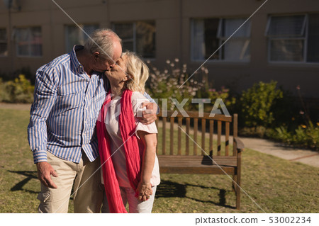 Senior couple kissing each other in the park Senior couple kissing each other in the park 53002234