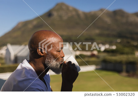 Senior man having coffee on the balcony 53002320