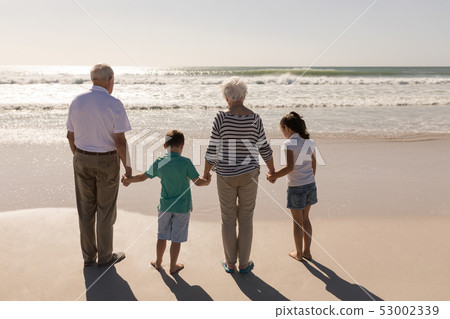 Family holding hands and standing on beach Family holding hands and standing on beach 53002339