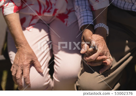 Mid section of senior couple holding hands Mid section of senior couple holding hands 53002376