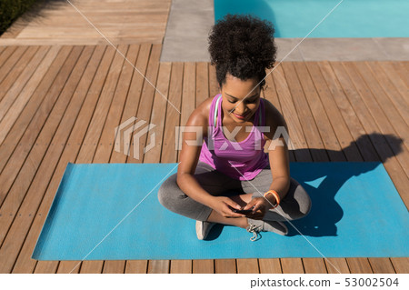 Woman using mobile phone in the backyard of home Woman using mobile phone in the backyard of home 53002504