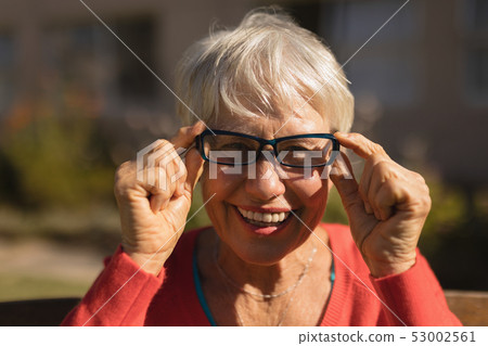 Senior woman in spectacle smiling in the park 53002561