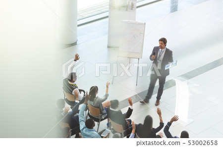 Businessman answering questions at business conference Businessman answering questions at business conference 53002658